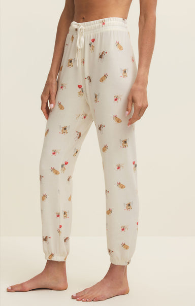 White pajama pants with small patterns worn by a person on a beige background