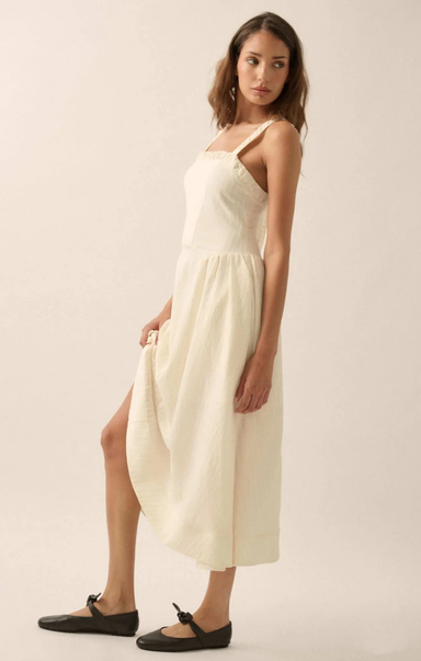 Woman wearing a white dress against a plain background