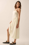 Woman wearing a white dress against a plain background