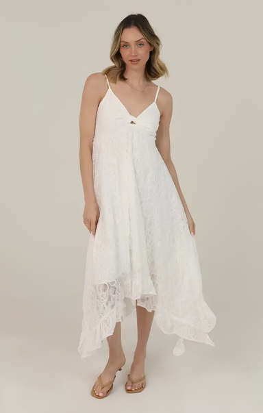Woman wearing a white lace dress on a plain background