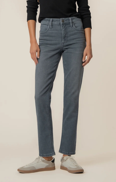 Person wearing mid-wash straight-leg jeans paired with a black long-sleeve top and light gray sneakers, shown from shoulders to feet against a neutral background.