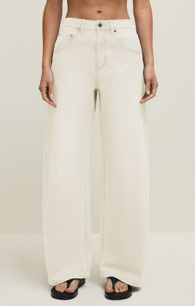 Person wearing white wide-leg jeans on a plain background