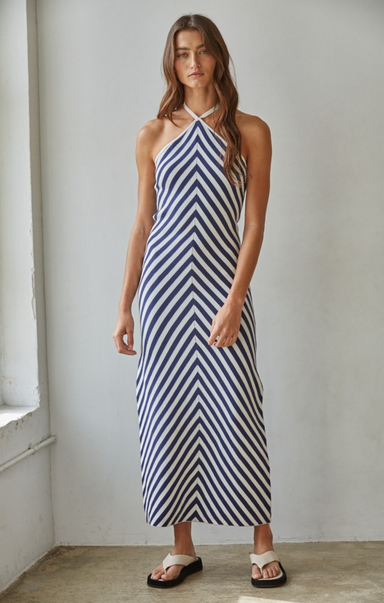 Woman wearing a blue and white striped dress against a plain background