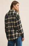 Person wearing a plaid shirt and jeans on a beige background