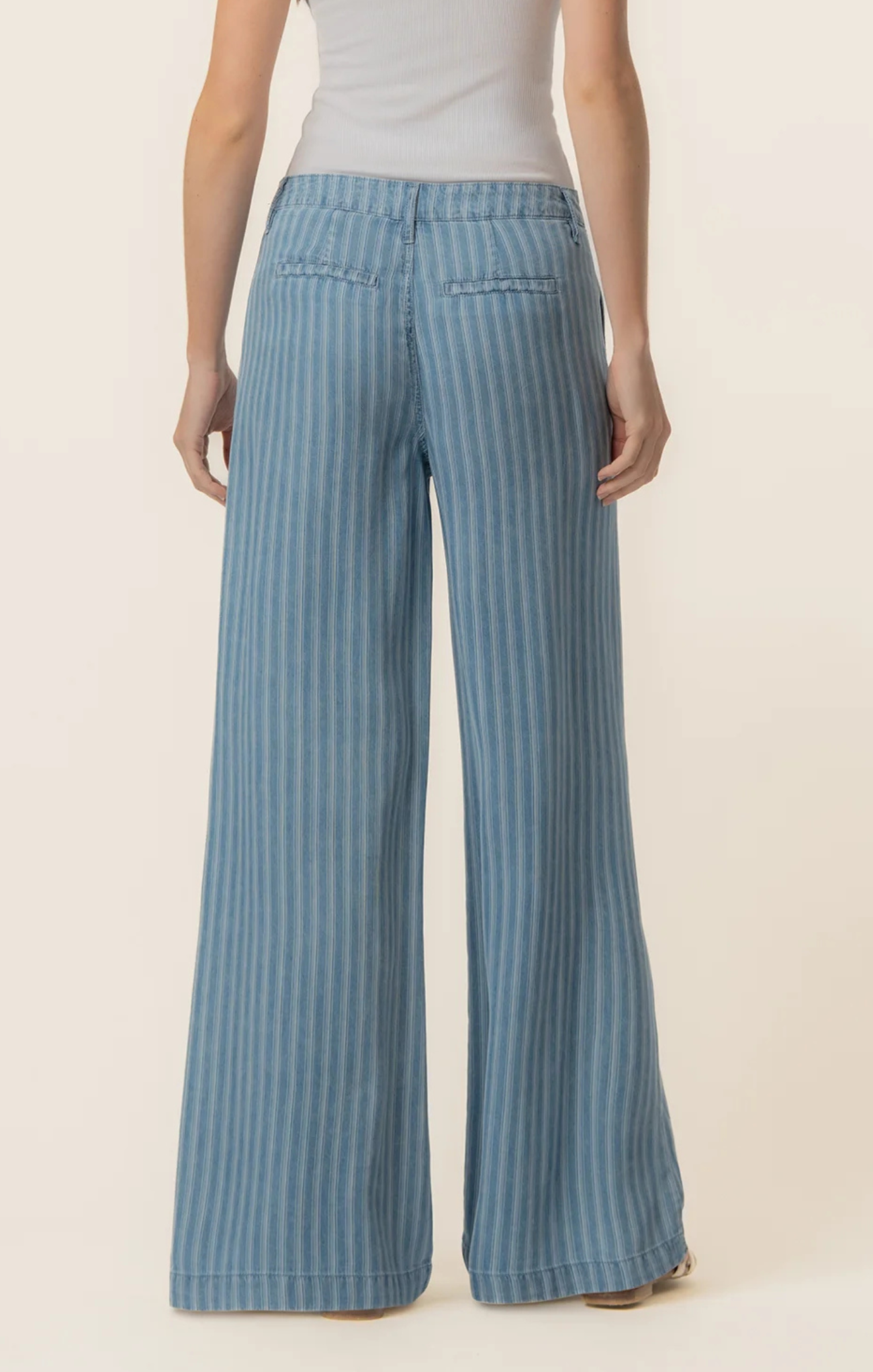 Blue striped pants worn by a person on a beige background