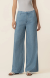 Person wearing blue striped pants on a beige background