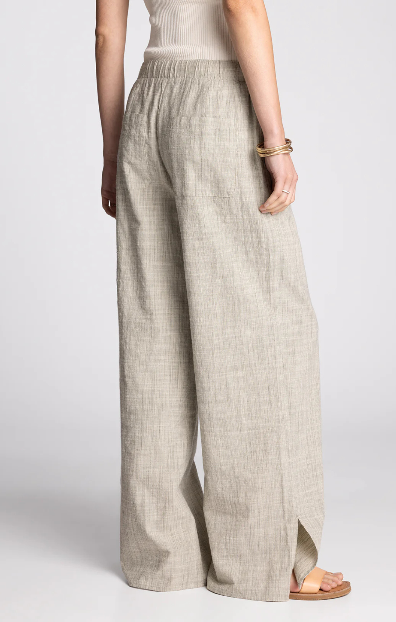 Beige wide-leg pants worn by a person on a white background