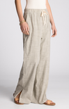 Person wearing light-colored wide-leg pants on a plain background