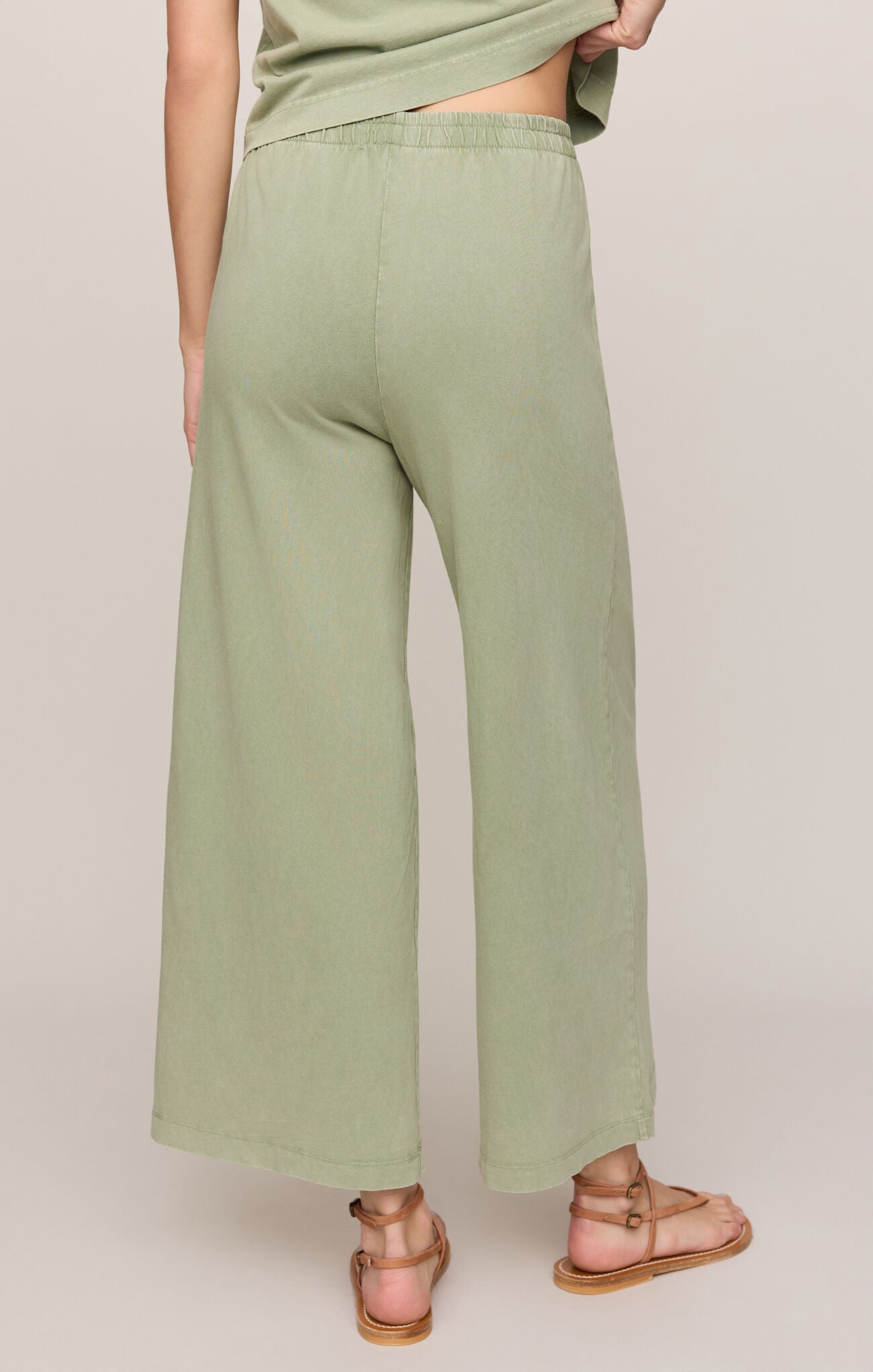 Person wearing green wide-leg pants on a plain background