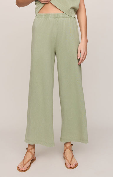 Person wearing light green wide-leg pants on a plain background