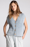 Woman wearing a light blue knitted vest with buttons on a white background