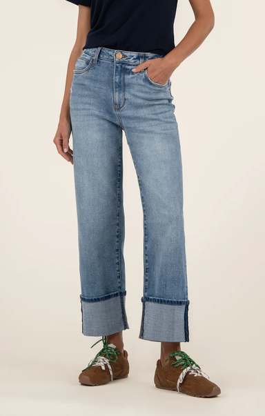 Person wearing light blue jeans with a plain background