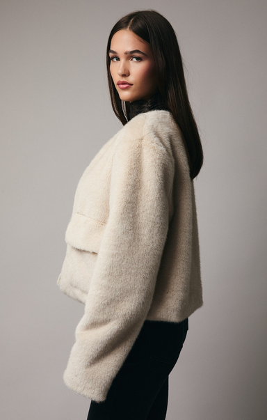 Woman wearing a beige sweater against a plain background