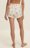 Person wearing floral shorts on a plain background