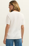 Woman wearing a white t-shirt and blue jeans on a plain background