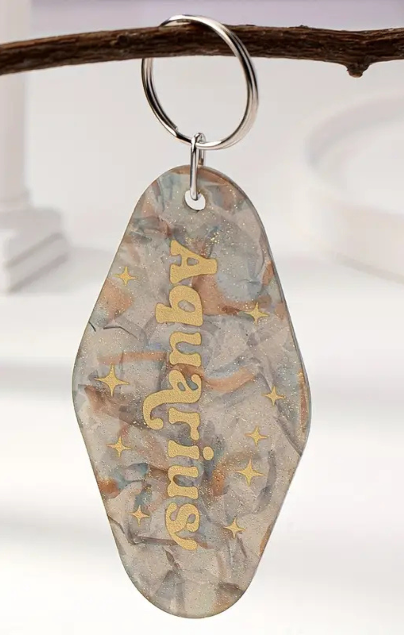 Decorative keychain with 'Angelina' engraved on a branch against a white background