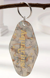 Decorative keychain with 'Angelina' engraved on a branch against a white background