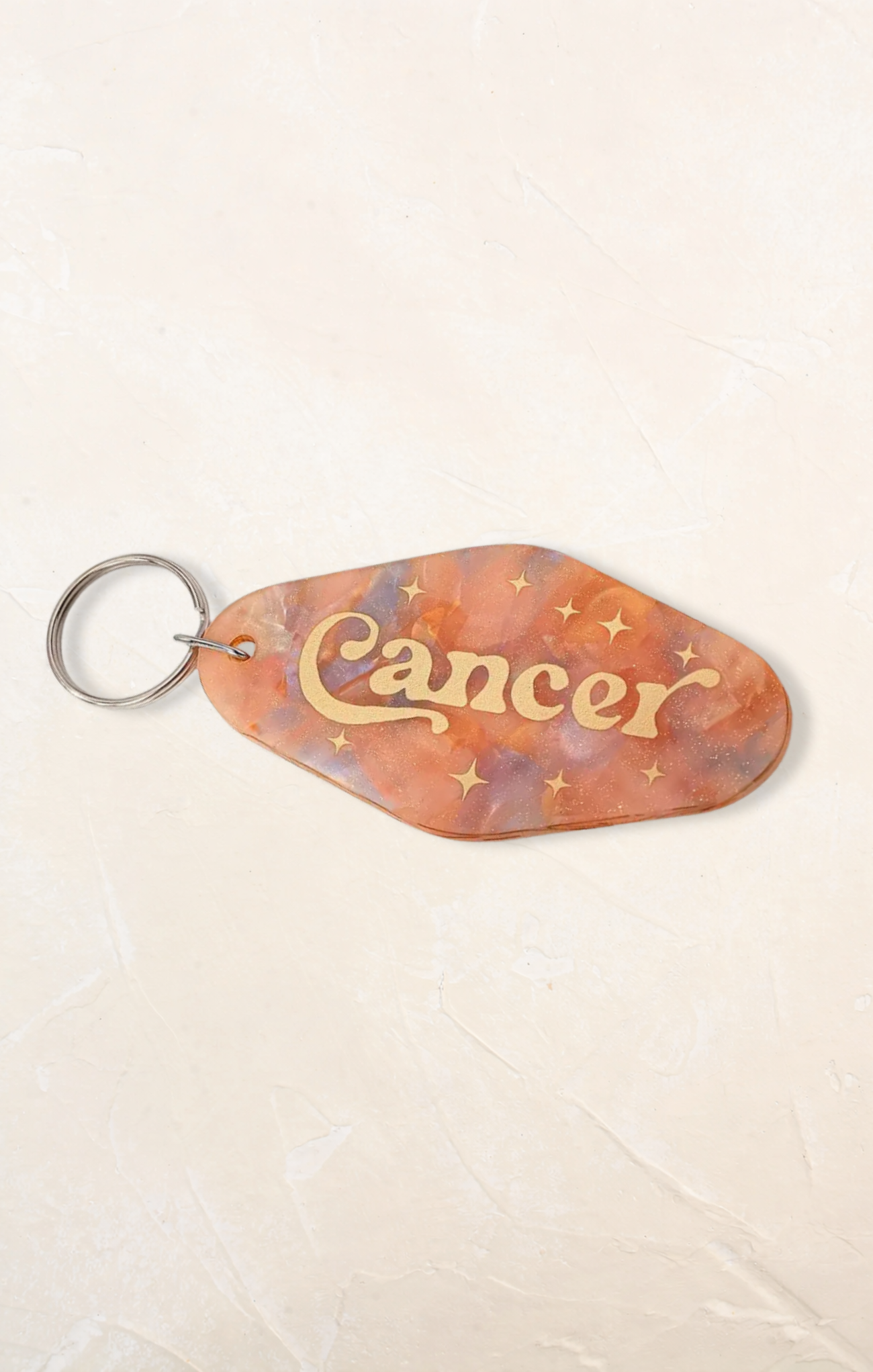 Keychain with 'Cancer' text on a beige background