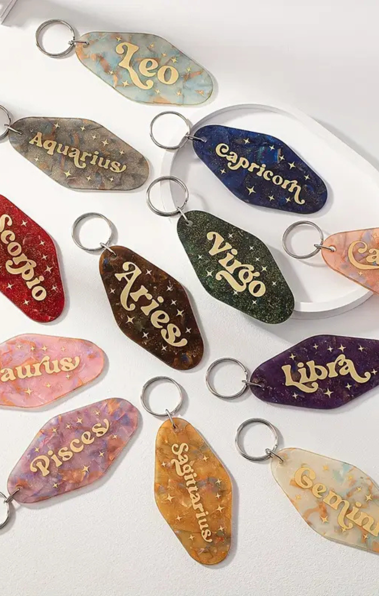 Set of zodiac-themed keychains on a white background