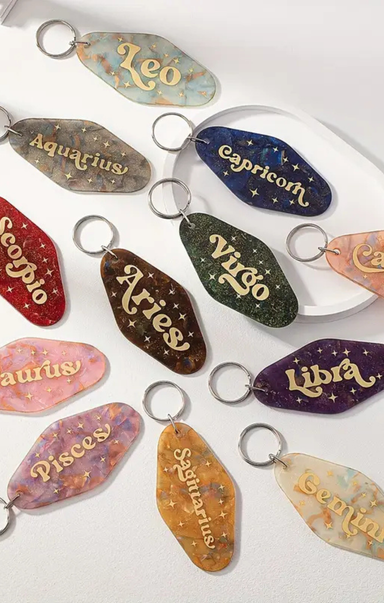 Set of zodiac-themed keychains on a white background