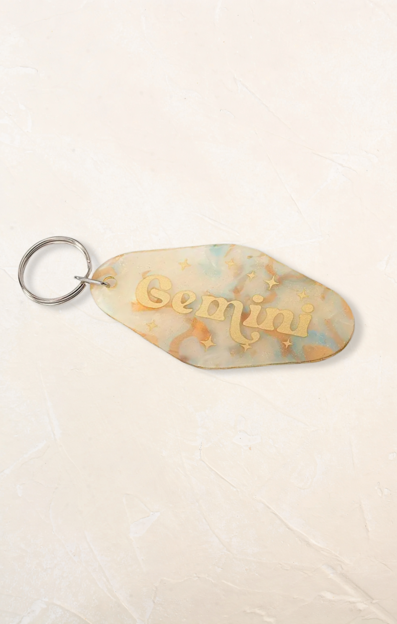 Keychain with 'Gemini' text on a beige background