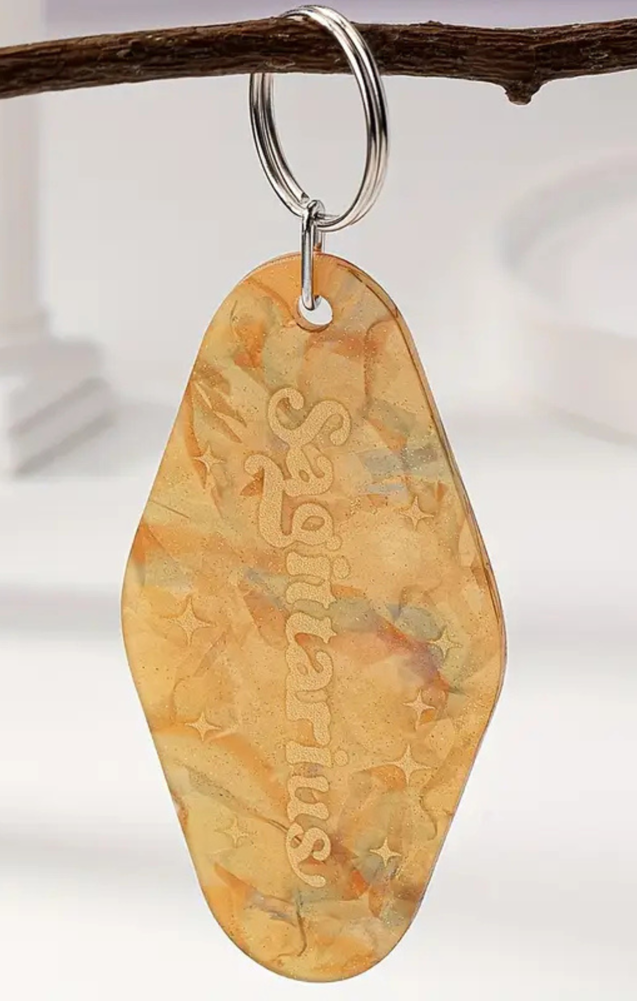 Keychain with 'Sagittarius' engraving on a branch