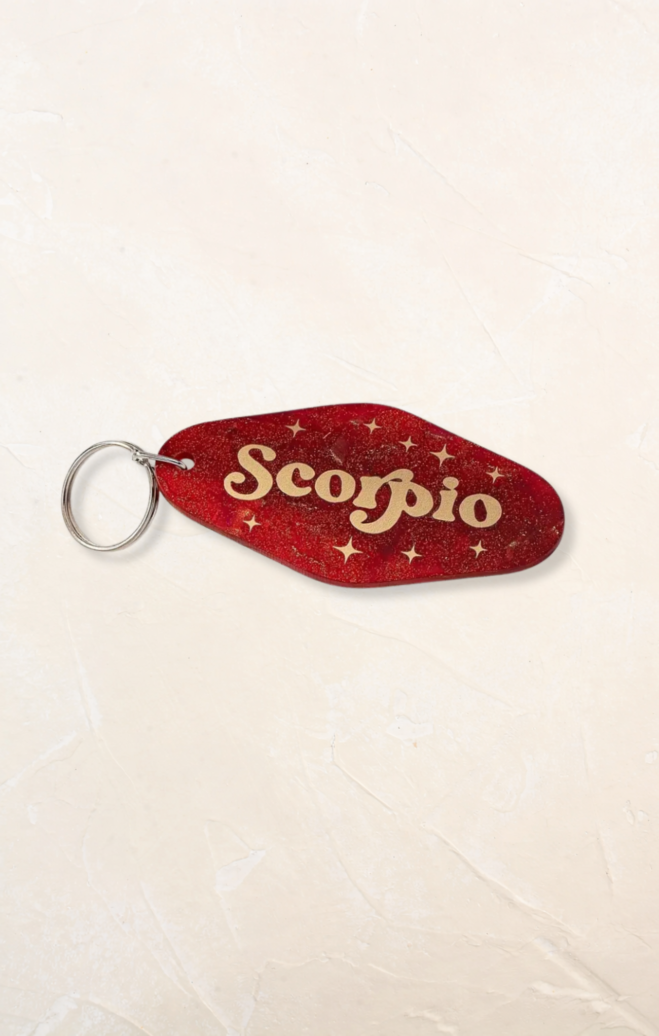Red 'Scorpio' keychain on a beige background