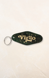 Keychain with 'Virgo' text on a green and gold design against a beige background