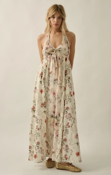 Woman wearing a floral maxi dress on a plain background
