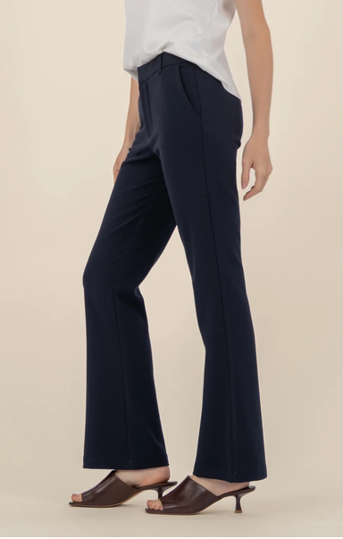 Navy blue pants worn by a person on a beige background