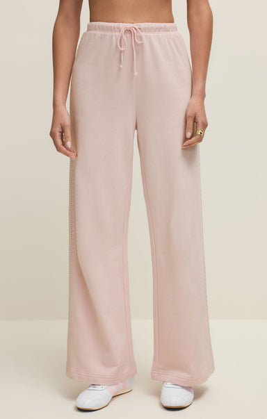 Pink pants worn by a person on a beige background