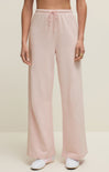 Pink pants worn by a person on a beige background