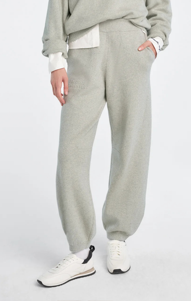 Person wearing gray sweatpants and a light gray sweater on a white background