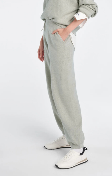 Person wearing light gray sweatpants and a matching top on a white background