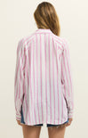 Woman wearing a pink and white striped shirt on a beige background