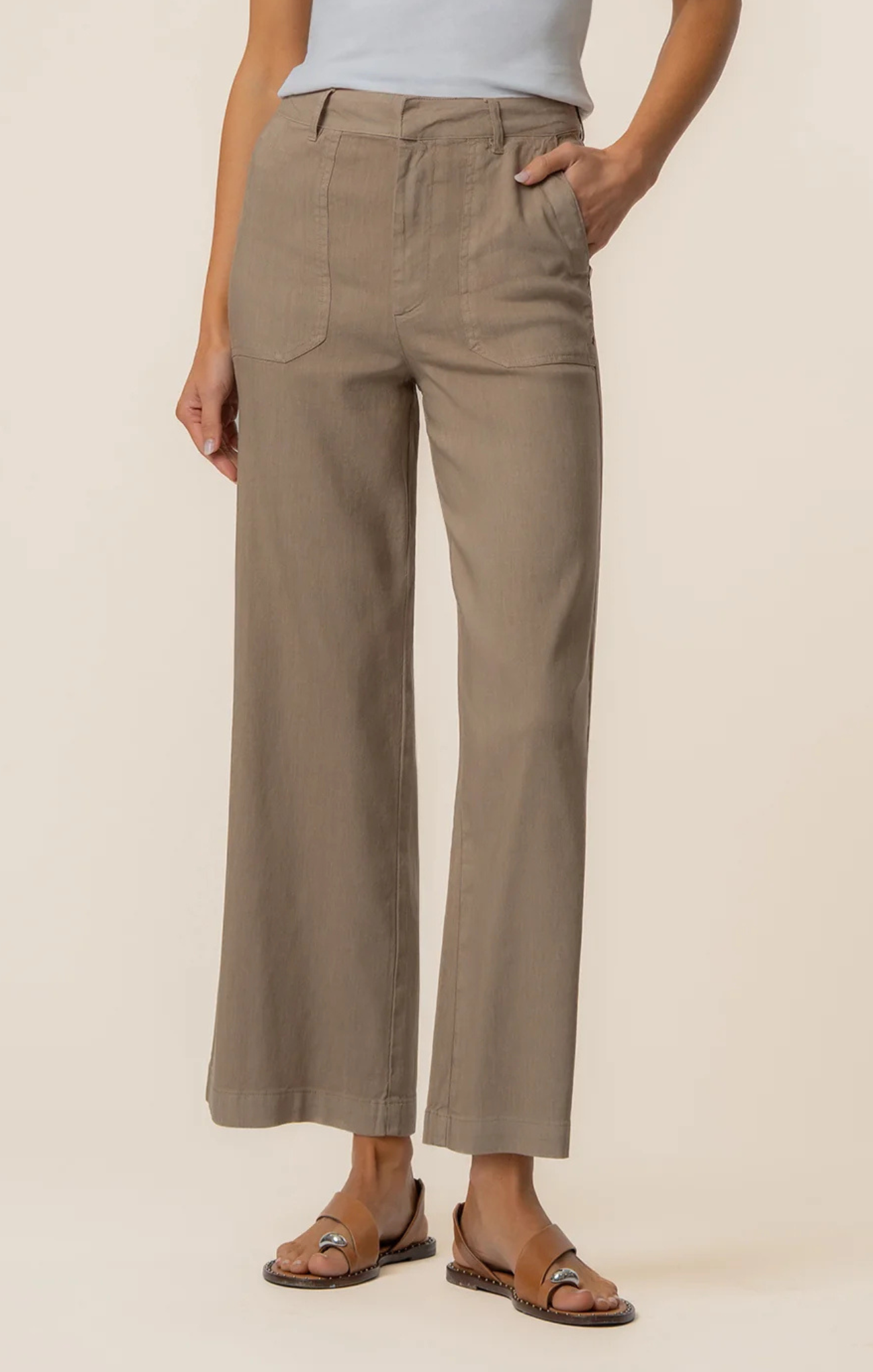 Person wearing beige pants on a plain background