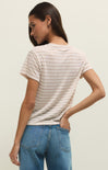 Woman wearing a striped t-shirt and blue jeans against a plain background