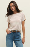 Woman wearing a striped shirt and blue jeans against a plain background