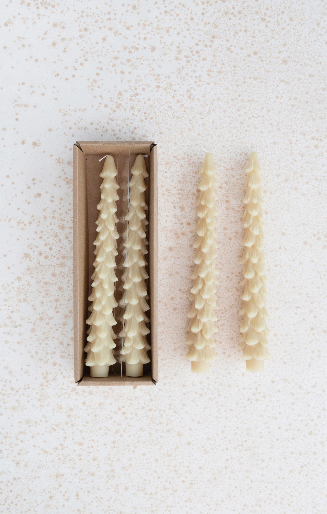 Set of decorative candles in a box on a textured white background