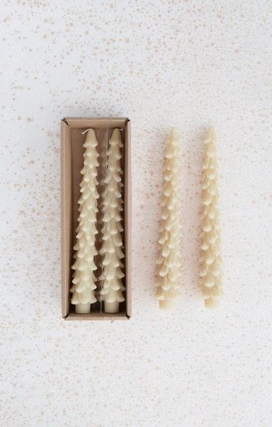 Set of decorative candles in a box on a textured white background