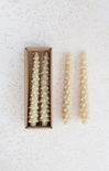 Set of decorative candles in a box on a textured white background