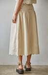 Beige skirt with lace details worn by a person on a plain background