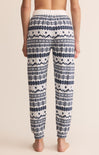 Patterned pajama pants worn by a person on a beige background
