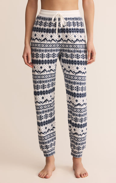 Patterned pajama pants worn by a person on a beige background