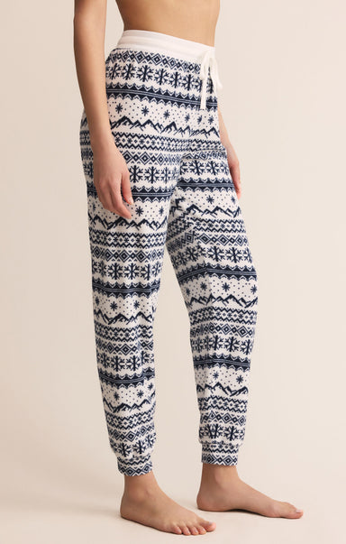 Patterned pajama pants worn by a person on a beige background
