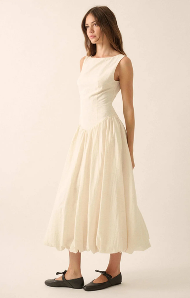 Woman wearing a white dress against a plain background