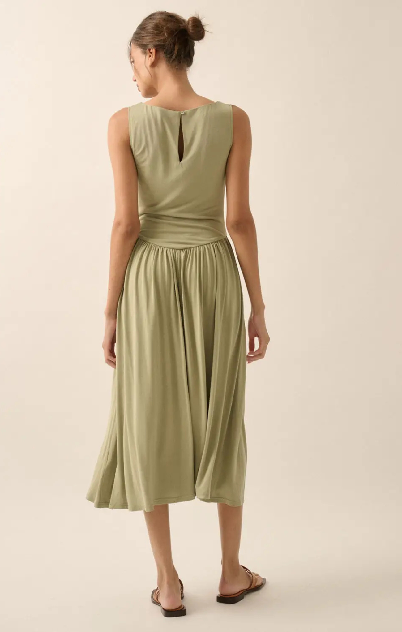 Woman wearing a light green dress on a beige background