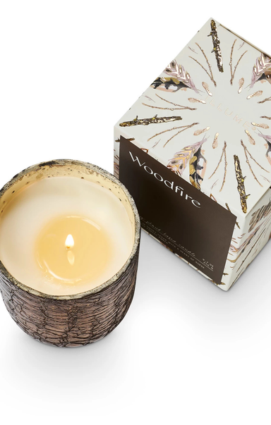 Wood-fired candle in a decorative container with a matching box on a white background