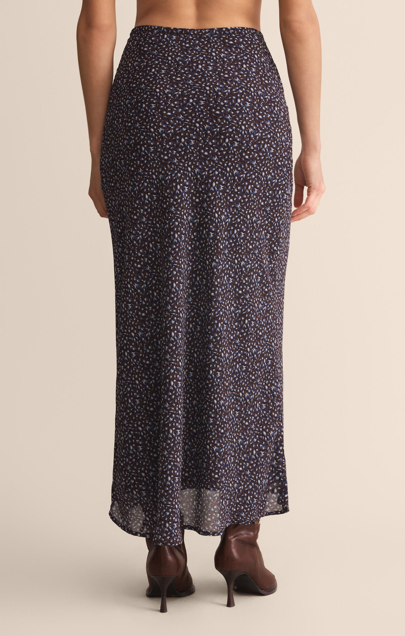 Long patterned skirt worn by a person on a beige background