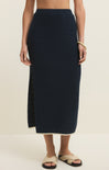 Person wearing a navy blue knit skirt on a beige background